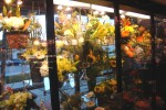 Custom floral case - glass shelving hung with airplane wire